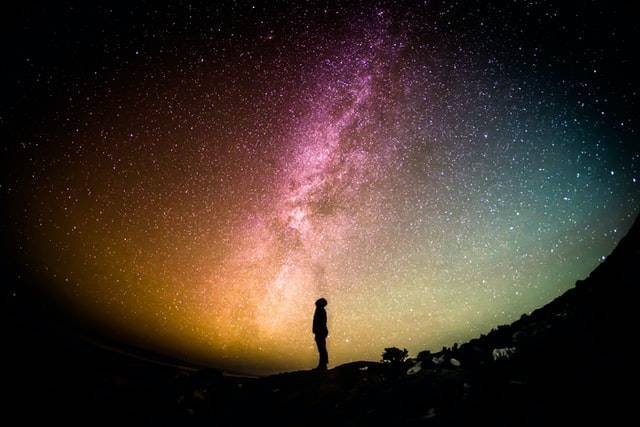 Silhouette of man looking to the stars and seeing the galaxy