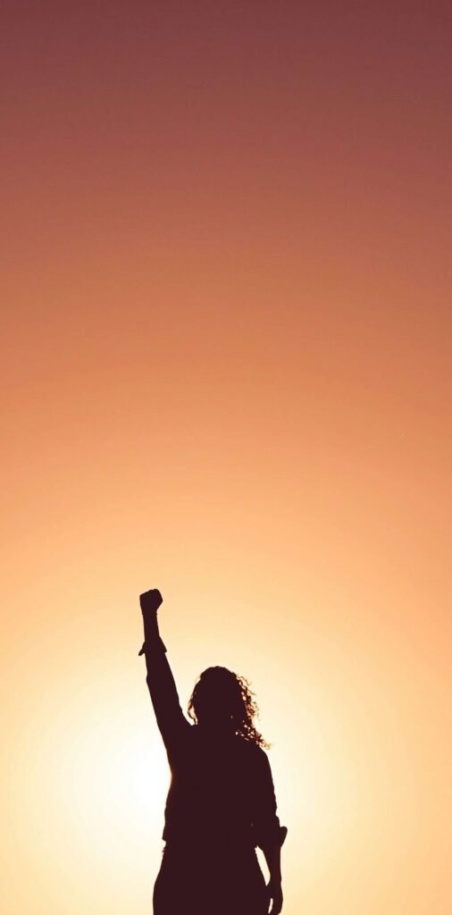 woman with one arm in the air feeling success from healing