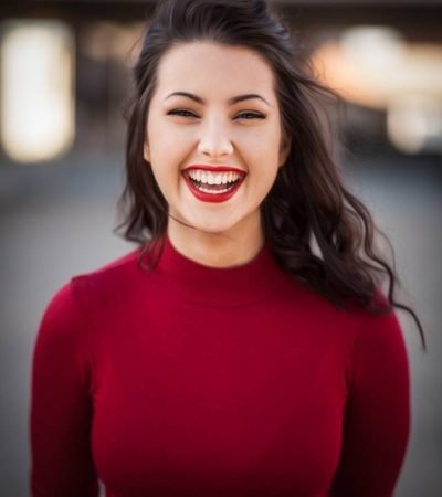 woman with red jumper with big smile
